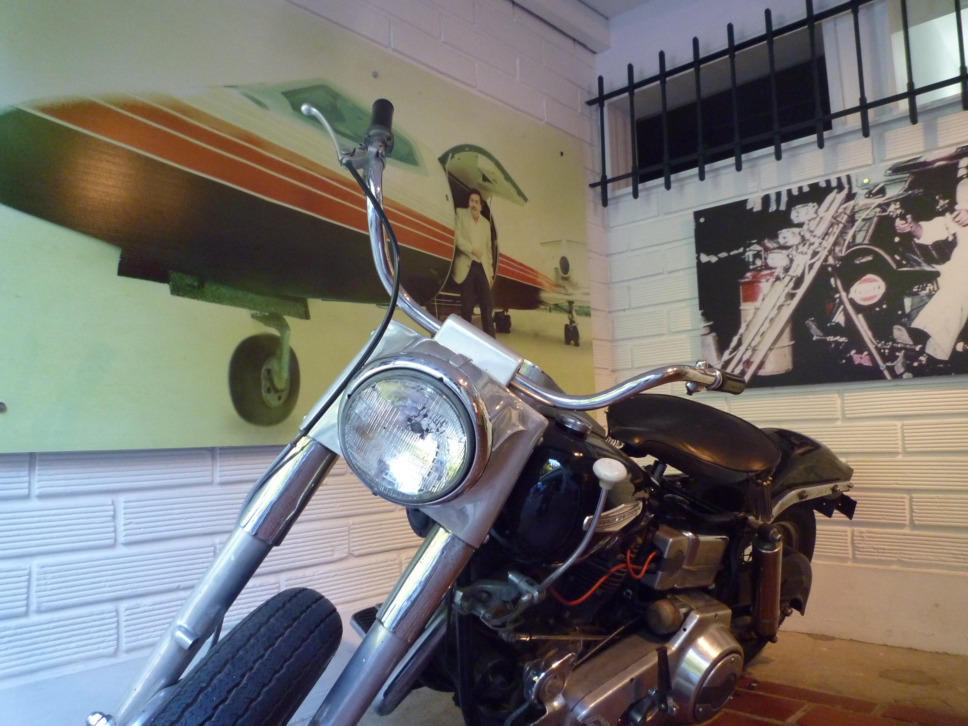 A Harley Davidson previously owned by Frank Sinatra In the background a picture of Escobar exiting a private jet
